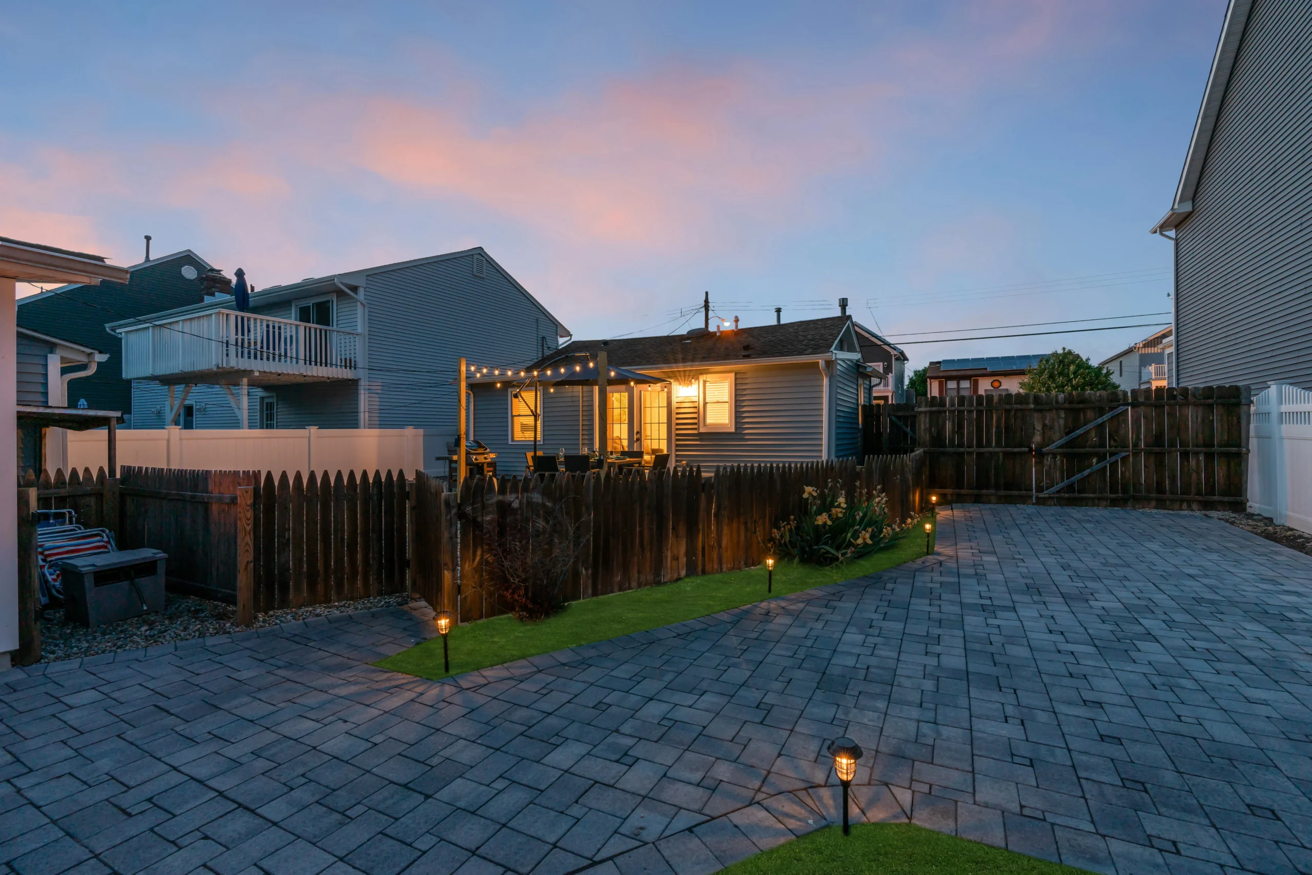 Evening view of affordable vacation rental compound in Panama City Beach with illuminated homes, patio, and string lights
