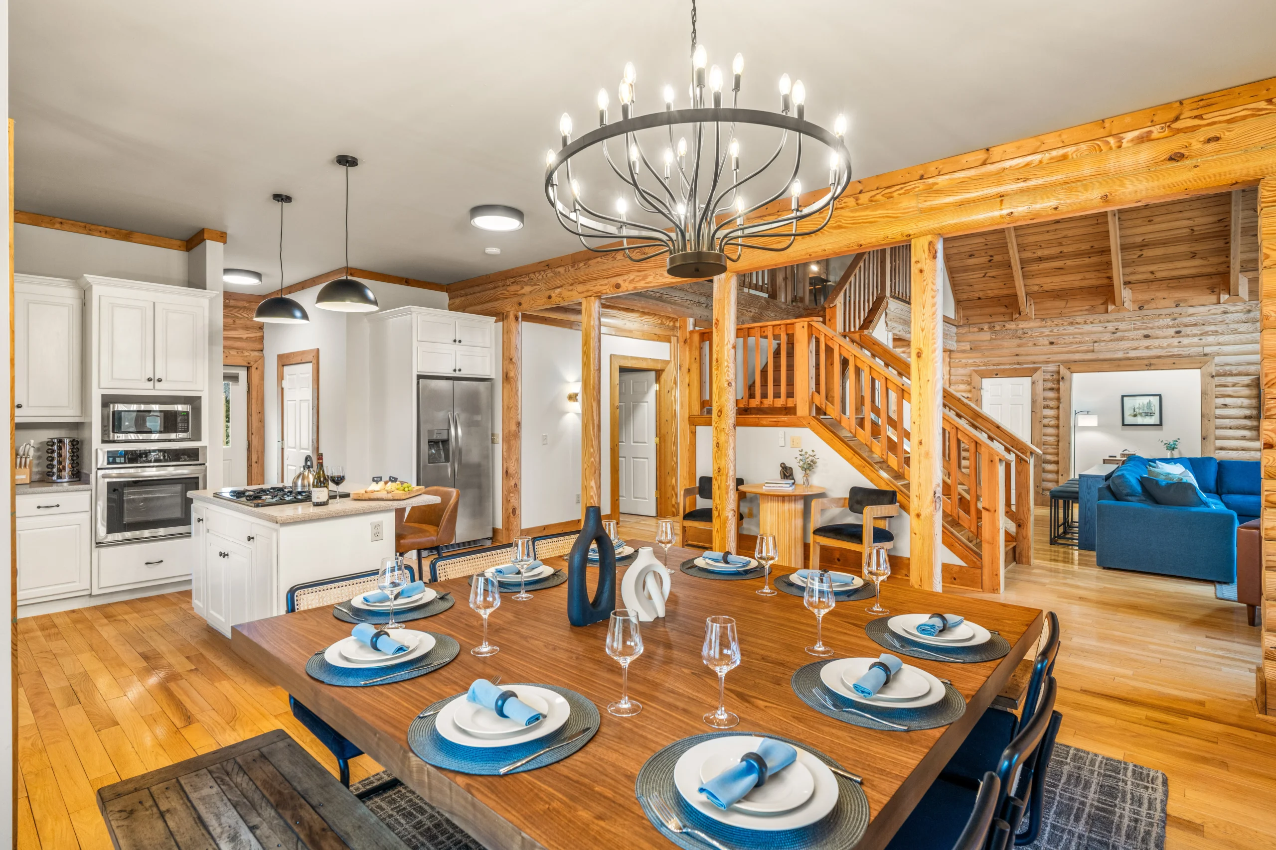 Dining table set for a group at Skyline Vista Retreat, with the kitchen and staircase behind