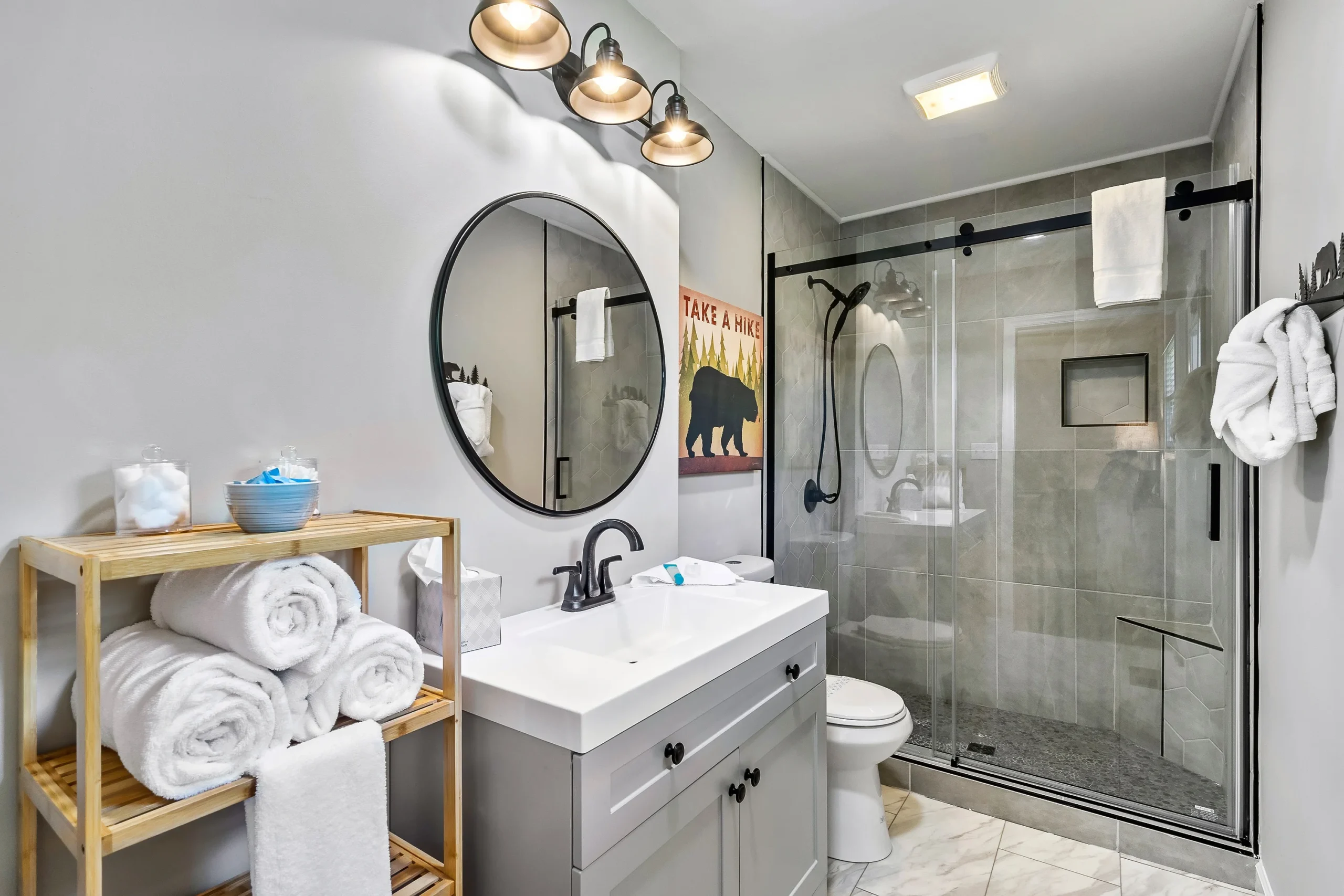 Modern cabin bathroom with white vanity, walk-in shower, and rustic décor in Luray VA