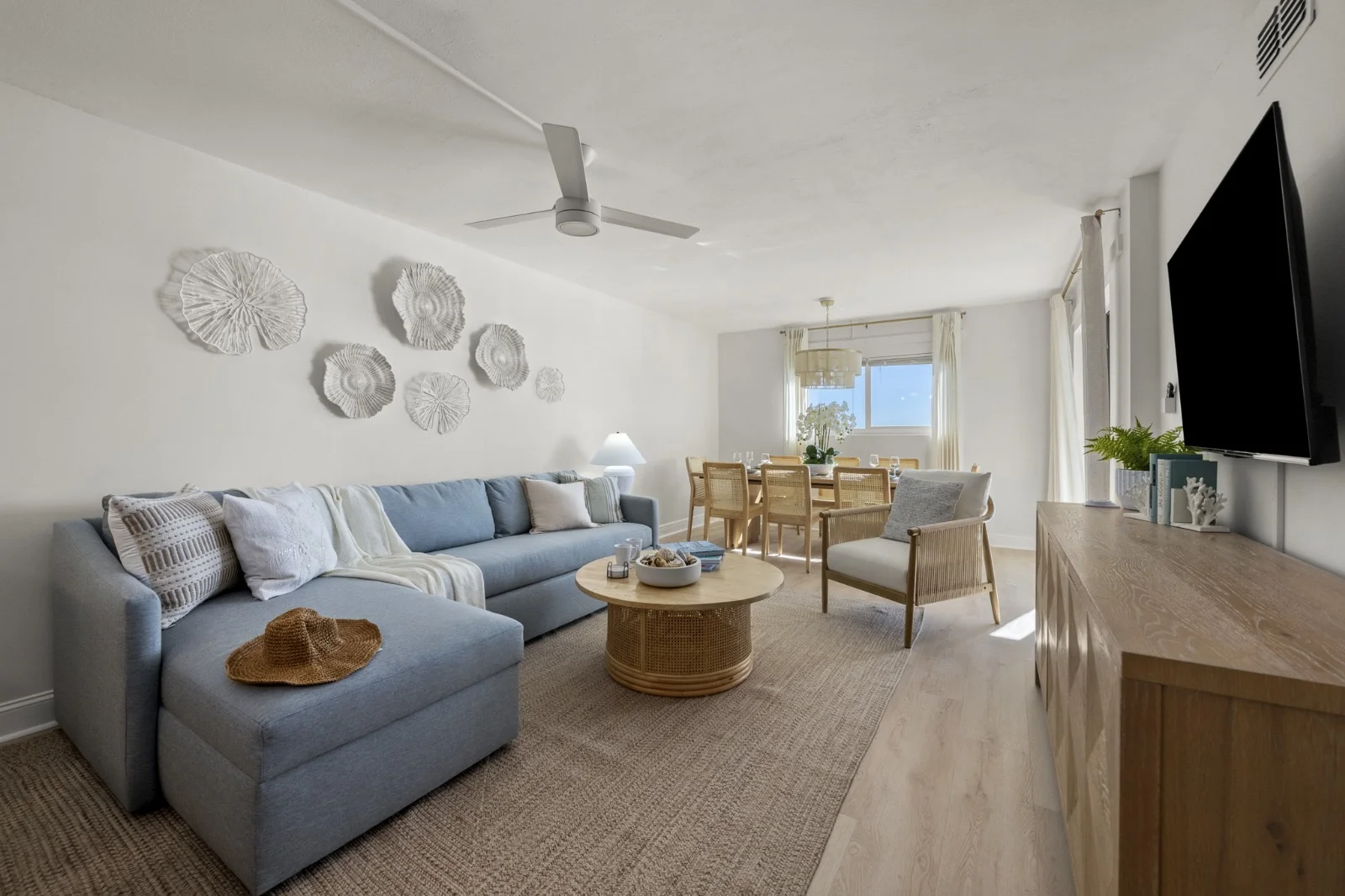Bright living room with light blue sectional sofa and ocean views in Panama City Beach Gulf-front condo rental