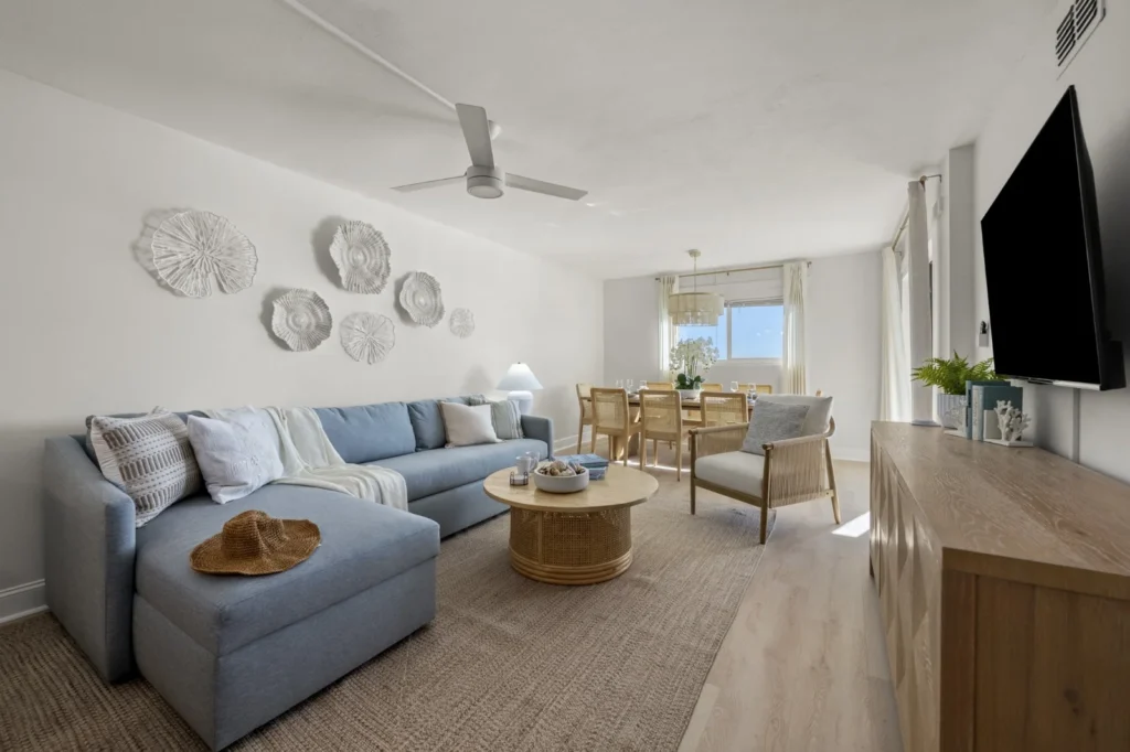 Bright living room with light blue sectional sofa and ocean views in Panama City Beach Gulf-front condo rental