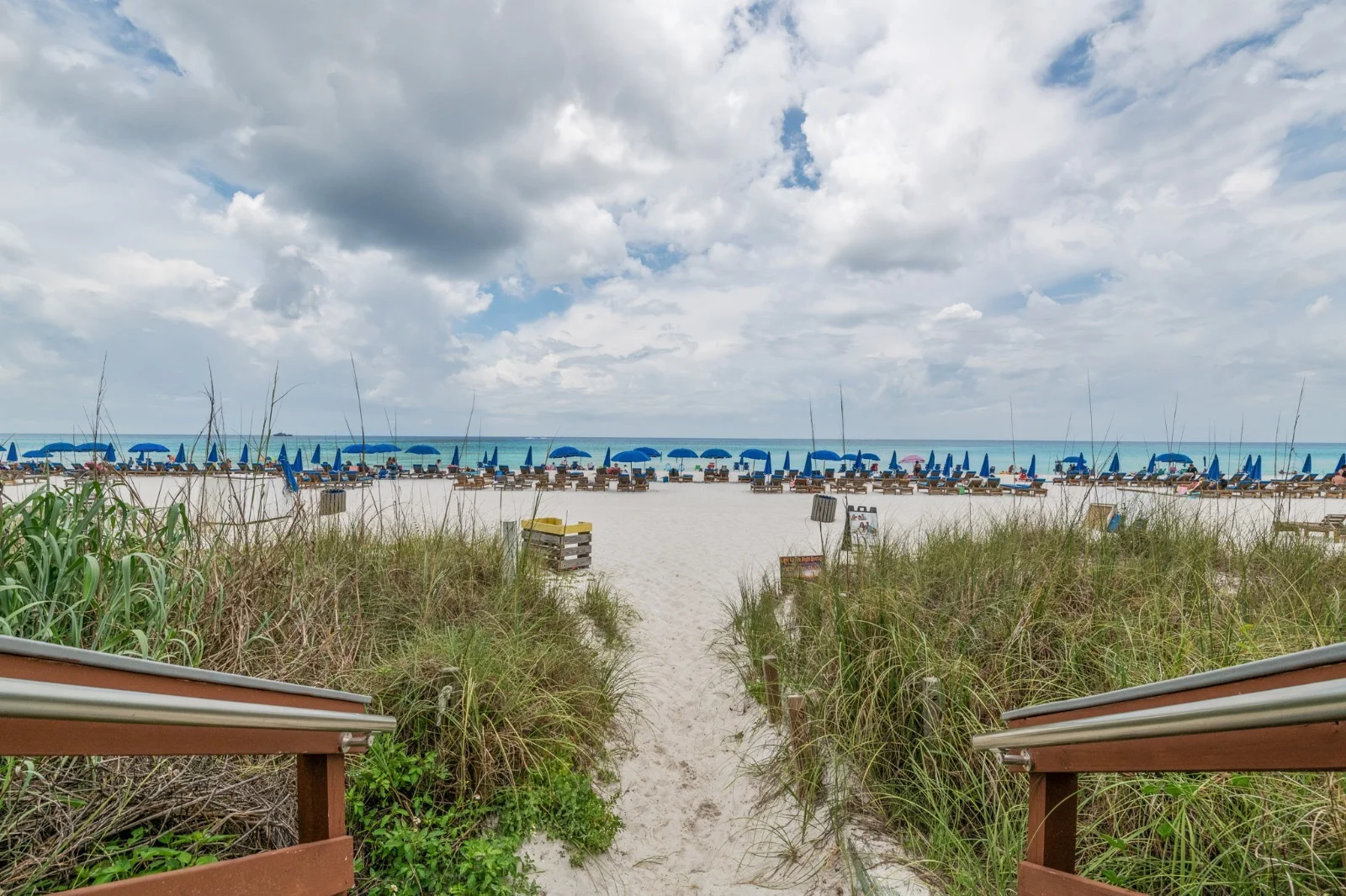Sandy beach view with umbrellas and sailboats at Panama City Beach Florida vacation rental
