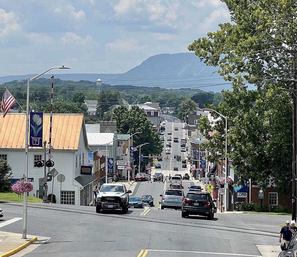 Looking down historic East Main Street in downtown Luray, Virginia, with storefronts and mountains beyond
