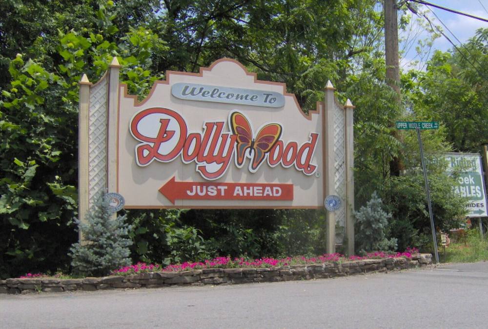 The Dollywood entrance sign beneath the treeline in Pigeon Forge