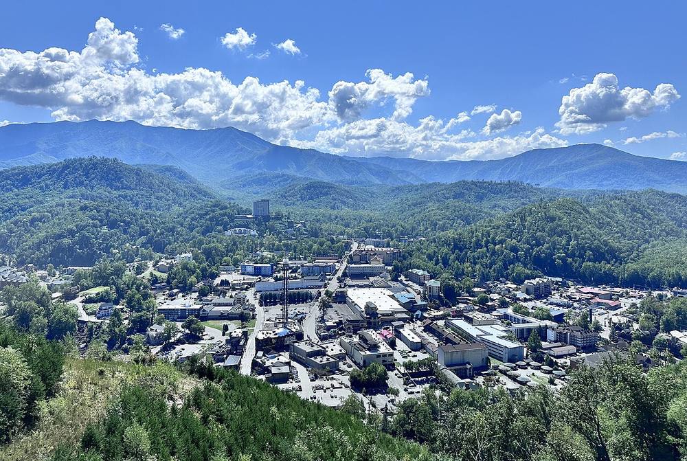 Downtown Gatlinburg from above, with the Smokies rising straight up behind the strip