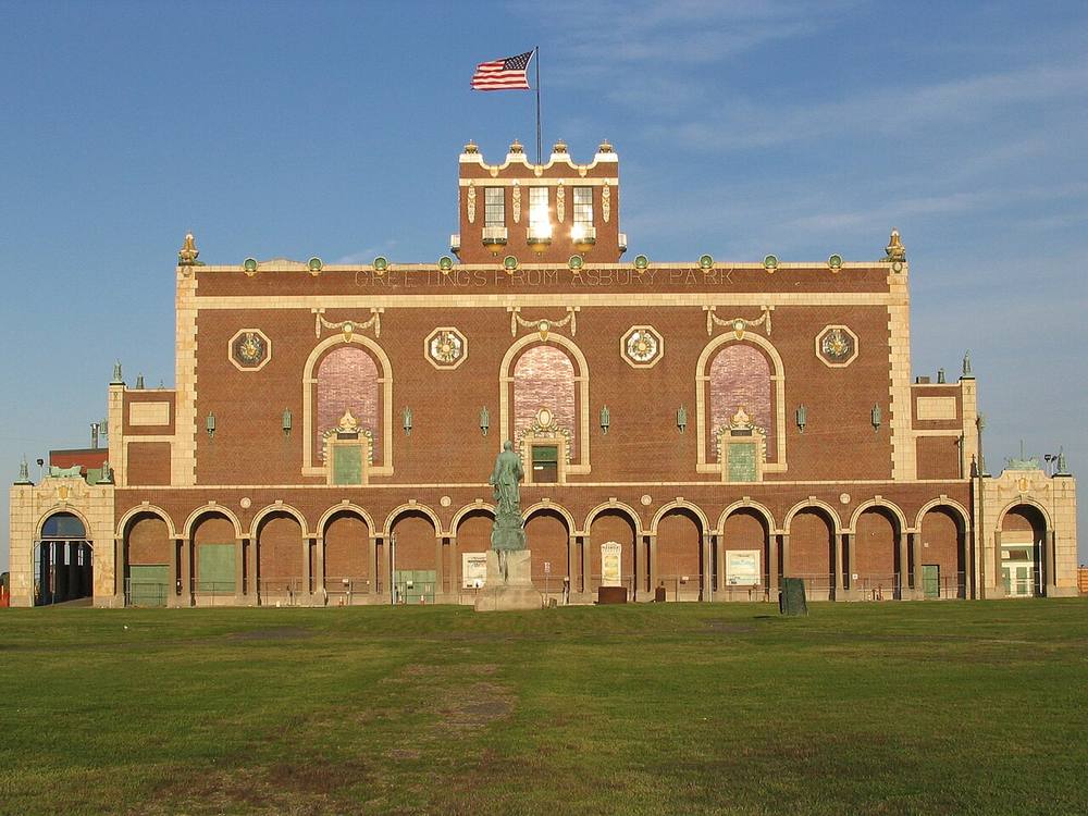 Asbury Park Convention Hall, a brick and terra cotta building with the words Greetings from Asbury Park across the facade