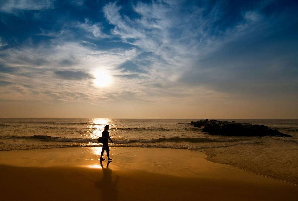 Spring Lake, New Jersey beach at sunrise with a person walking along the shoreline